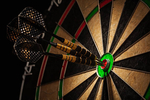 Success hitting target aim goal achievement concept background - three darts in bull's eye close up